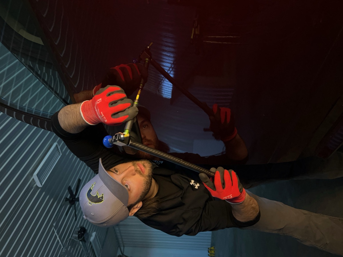 Big Lou using a paintless dent repair rod on a red truck